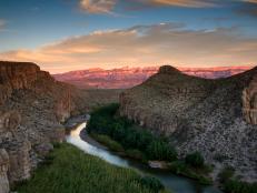 Beyond the natural hot springs of Boquillas Canyon in Big Bend National Park, Texas, the Rio Grande River snakes along the cliffs along the trail to Rio Grande Village. The Rio Grande is a natural border separating Mexico (on the right) from the United States (left). In the distance the Sierra Del Carmen Mountains are visible. During the day, the desert looks almost monochromatic, with neutral tones domination, but as the sun sets, colors and contrast begin to pop, with a range of pastels bouncing off every surface. It's also a lot cooler, which makes longer hikes much easier.