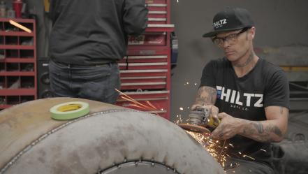 Chad Hiltz sanding down motorcycle frame.