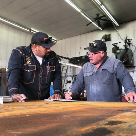 Freddy Dodge and Juan Ibarra measuring up in a notebook.