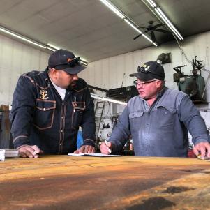 Freddy Dodge and Juan Ibarra measuring up in a notebook.