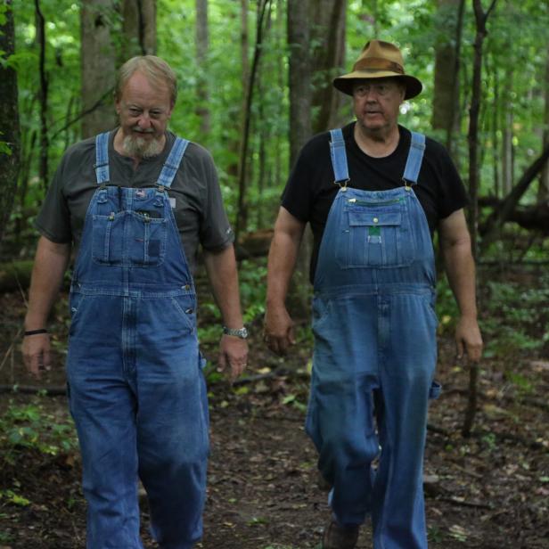 Digger and Mark walking through the woods to their hidden still sites.