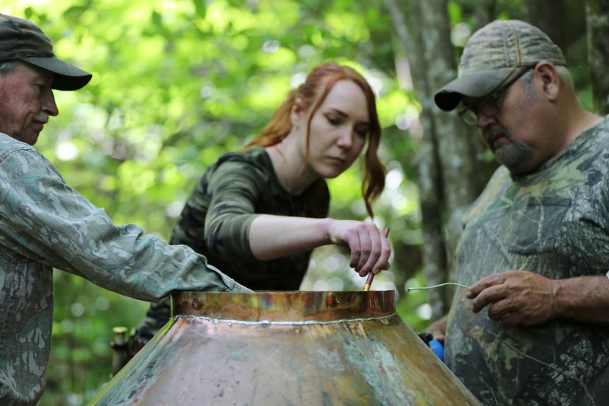 Mark, Amanda and Huck building their still together.